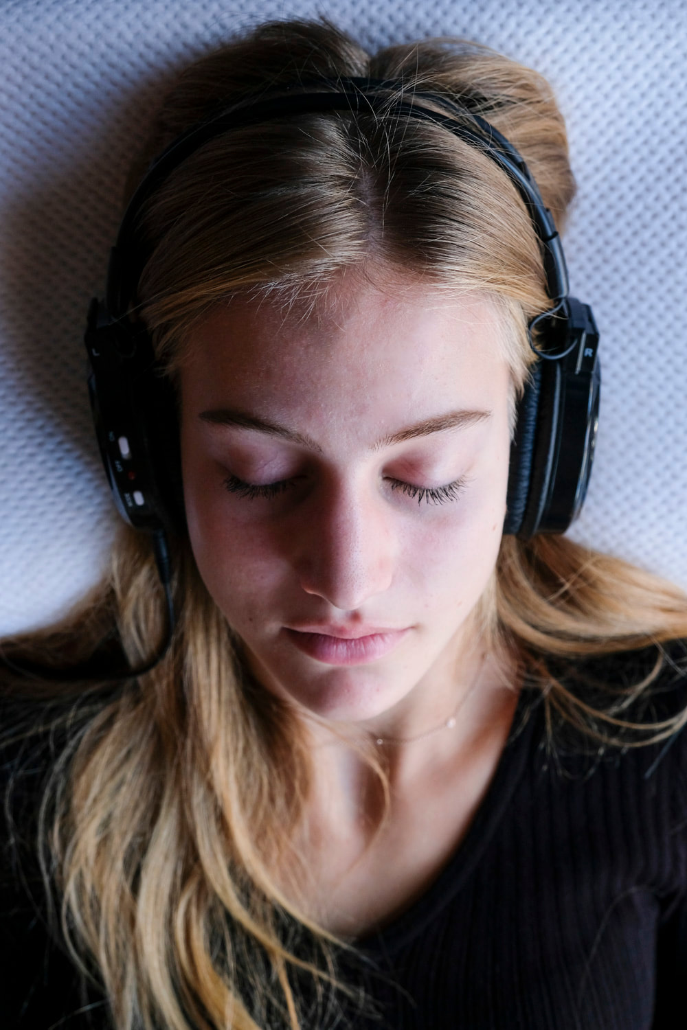 Blond girl sleeping with large headphones on