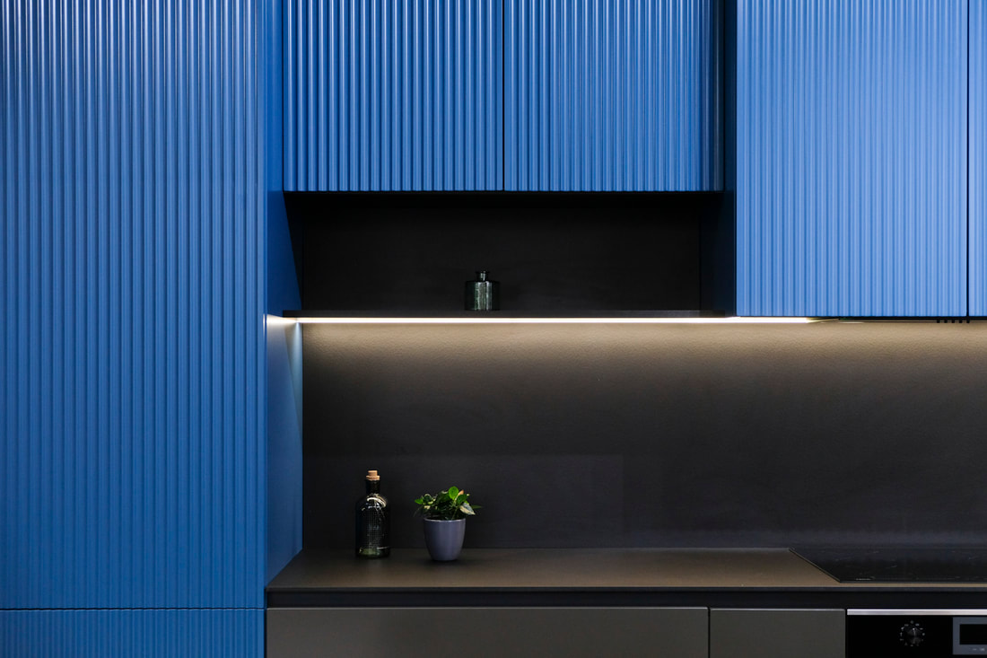 Detail of minimalist kitchen counter with blue cabinets