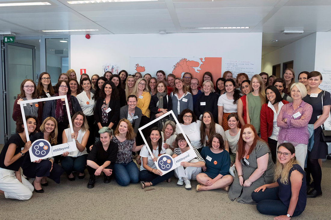 Large group of women posing for a picture in an office