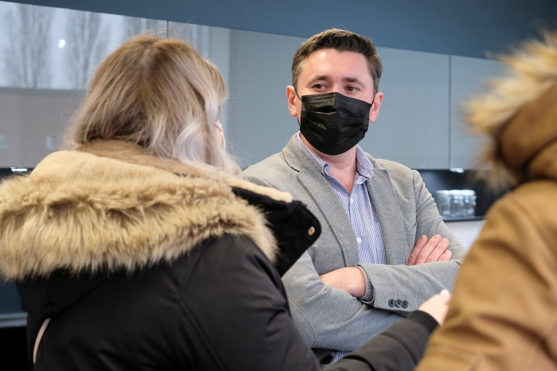Business man with black face mask talking to woman