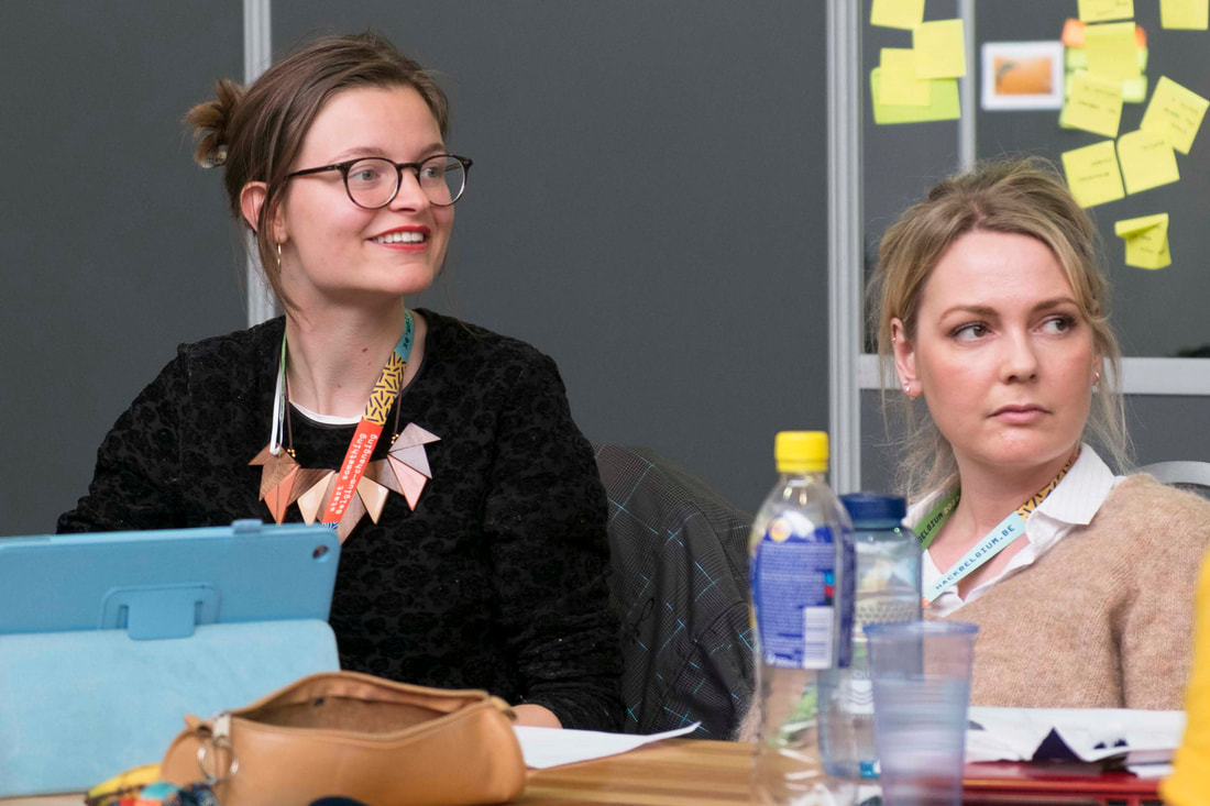 Two women sitting at a corporate meeting